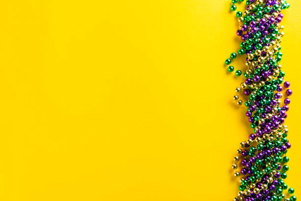 Mardi gras carnival concept - beads on yellow background Mardi gras carnival concept - beads on yellow background, top view Bead stock pictures, royalty-free photos & images