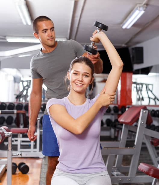 istock Man coaching girl with dumbbells 1095278370