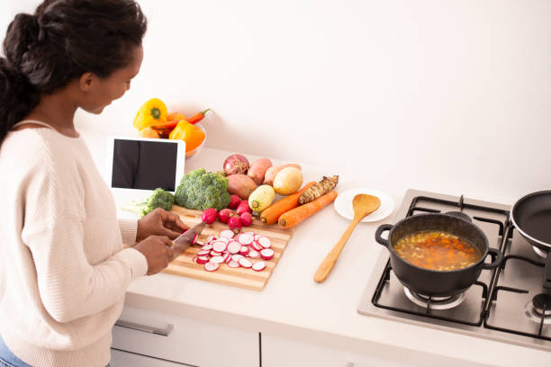 istock Kitchen woman trying new recipe found online on digital tablet. 1095286648