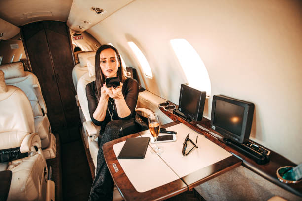 istock Successful woman touching up her make-up using a pocket mirror while traveling on a private jet 1095292074