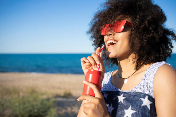 istock Woman with american flag drinking red cocktail 1095301618