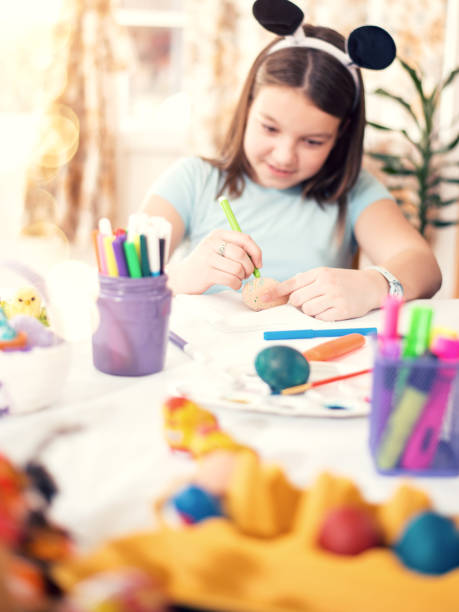 istock Little girl painting easter eggs 1095302198