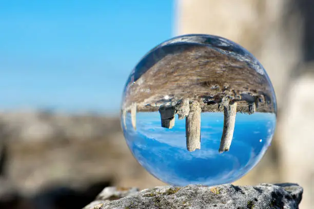 Photo of Upside down landscape of Pobiti Kamani, The Stone Forest Natural Reserve near Varna in Bulgaria, Eastern Europe - reflection in a lens ball - selective focus, space for text