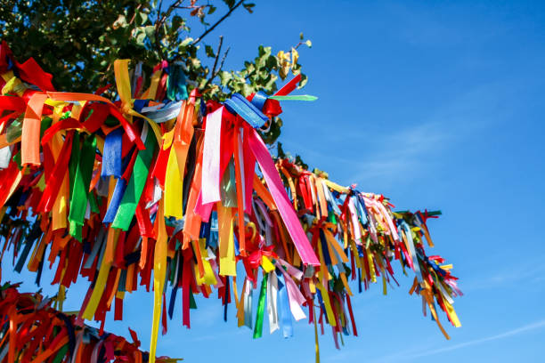 Multicolored ribbons on the branches of a tree against the sky