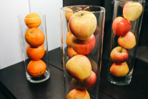 istock Fruit in glass vases standing on the table. apples and oranges in decorative interior design. Fresh vegetarian vitamins. 1095317692