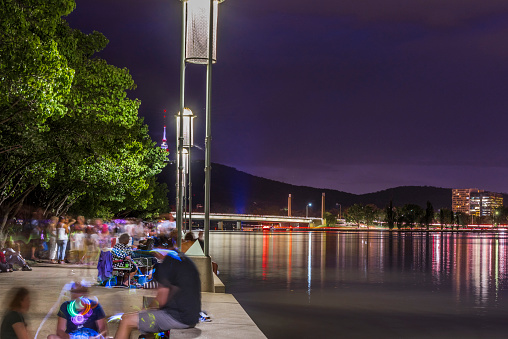 Canberra, Australia - December 31, 2018: Night view of New Year’s Eve, Large Group of People watching Fireworks at Lake Burley Griffin in Canberra.
