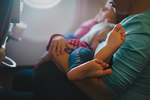 mother holding little baby on travel by plane, family travelmother holding little baby on travel by plane, family travel