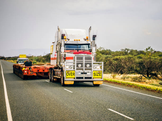 a semi truck with a trailer drives down the road