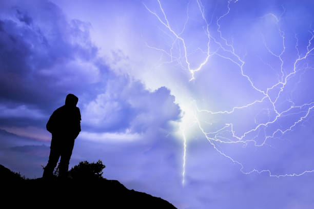 silhouette eines einzigen mannes vor gewitter - people traveling flash stock-fotos und bilder