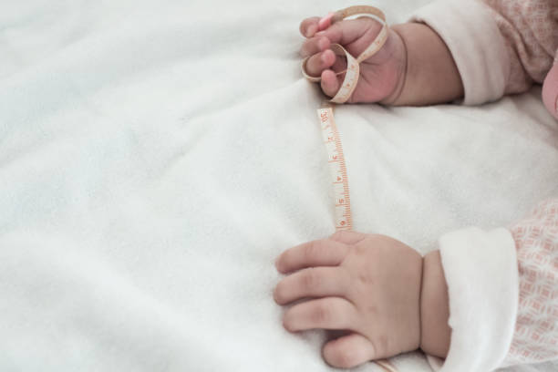 istock Baby hand and measuring tape 1095331610