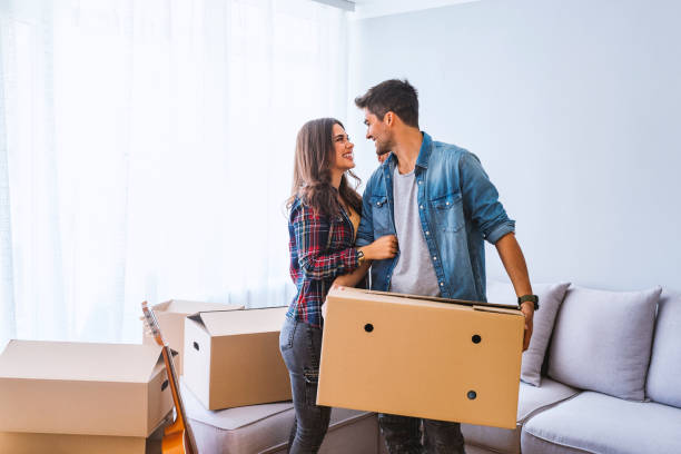 istock Couple holding cardboard boxes while moving home 1095332102
