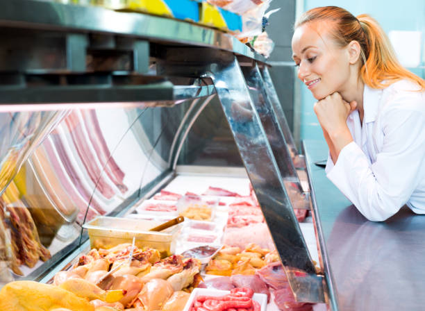 istock Female seller wearing uniform working with fresh meat 1095338802