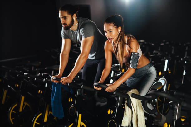 istock Two young people exercising on exercise bike at gym 1095343666