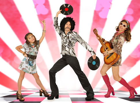 The family dressed in the style of disco with a guitar and vinyl records dancing on a vivid colorful background