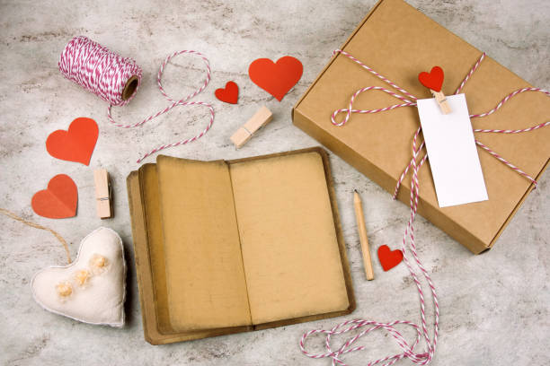 istock open noteboock with old vintage paper, pencil, gift box with blank white label, hearts 1095355772