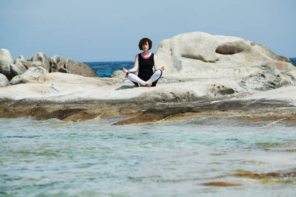 istock Woman practicing yoga at the beach 1095358444