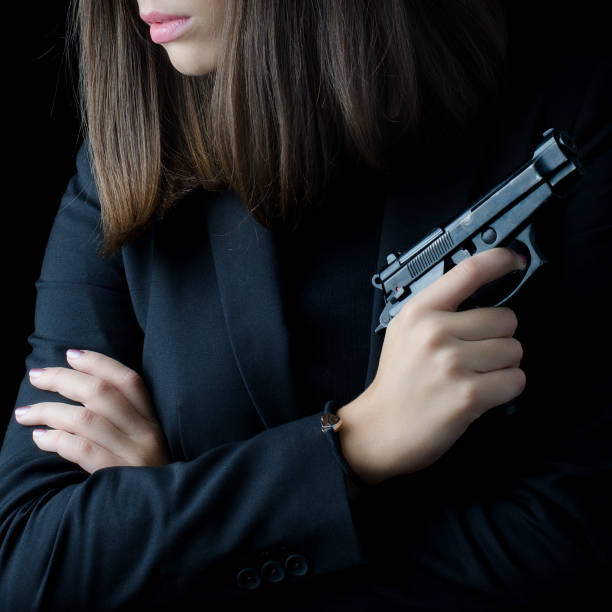 istock Elegant woman holding gun 1095360670