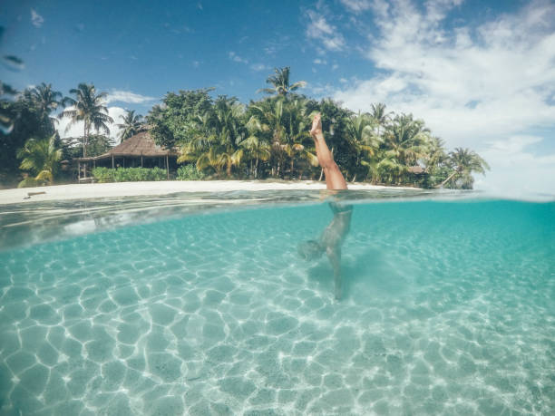 istock Young woman doing hand stand in the ocean 1095362514