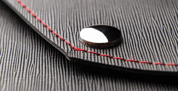 Leather black close up, rivet and red thread business style background. Banner concepts