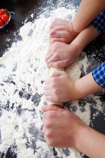 istock Cropped Hands Of Children Kneading Dough On Kitchen Counter 1095363644
