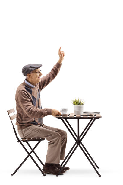 istock Senior man sitting at a coffee table and gesturing to call a waiter 1095372382