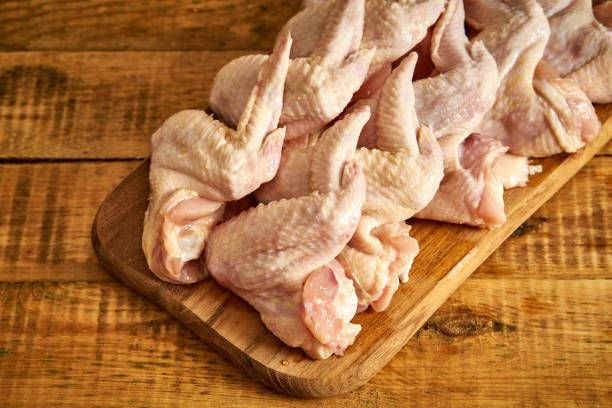 istock Fresh raw organic chicken wings on chopping board on wooden table. 1095375802
