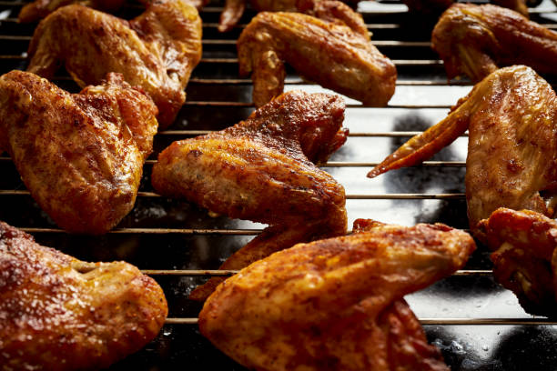 istock Delicious hot grilled chicken wings on grid grill. 1095378322