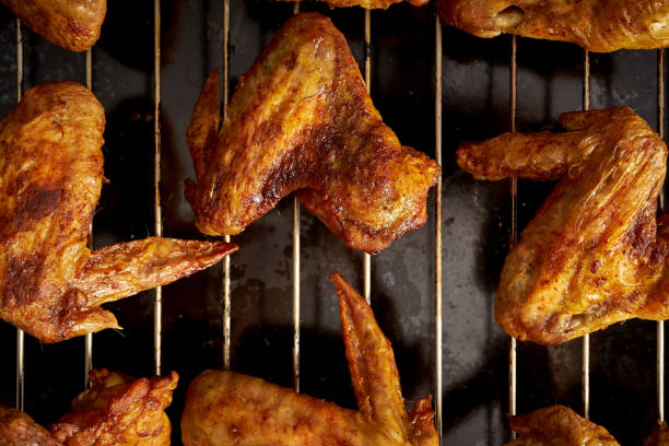 istock Delicious hot grilled chicken wings on grid grill. 1095378358
