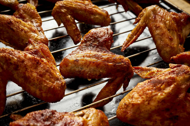 istock Delicious hot grilled chicken wings on grid grill. 1095378370