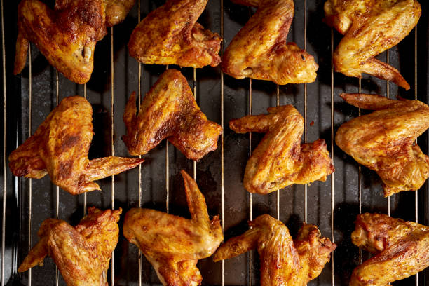 istock Delicious hot grilled chicken wings on grid grill. 1095378452