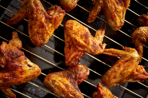 istock Delicious hot grilled chicken wings on grid grill. 1095378500