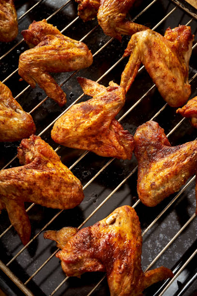 istock Delicious hot grilled chicken wings on grid grill. 1095378520