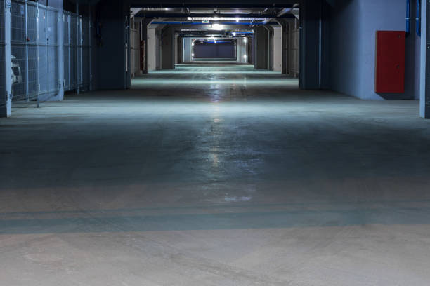 istock Dark coridor in underground parking garage with separate boxes, view on the way out 1095381392