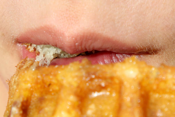 istock Female Lips Bite Waffle Pieces Close up 1095382516