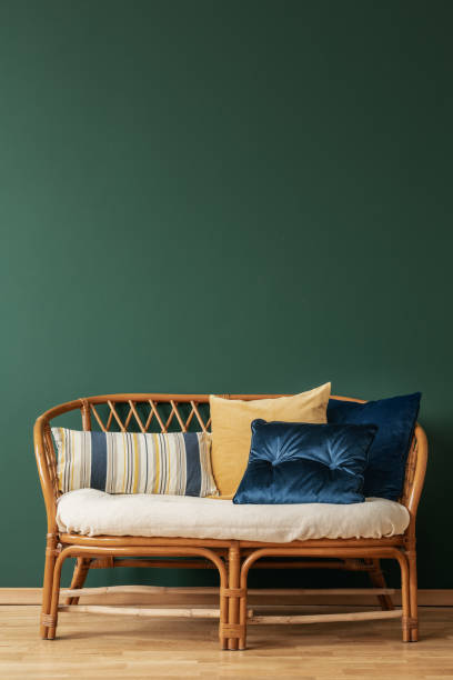 istock Rattan sofa with pillows in elegant living room interior with copy space on the empty grey wall 1095383052