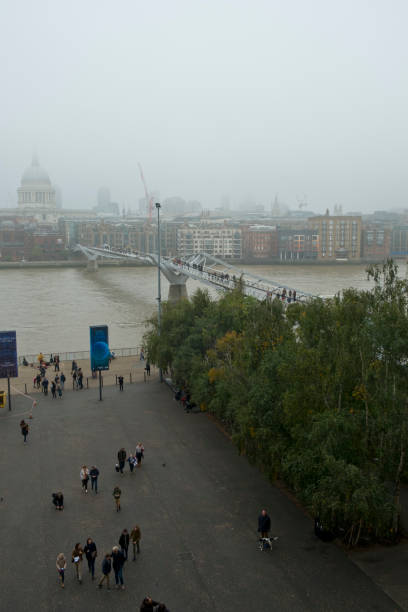 guardando attraverso il tamigi e il london millennium footbridge verso la cattedrale di st pauls e la city di londra - st pauls cathedral tourism river fog foto e immagini stock