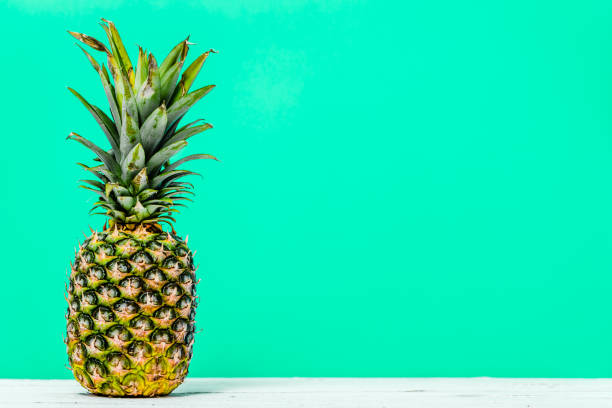 istock Fresh pineapple isolated on green background. Tropical fruit on table. 1095386730