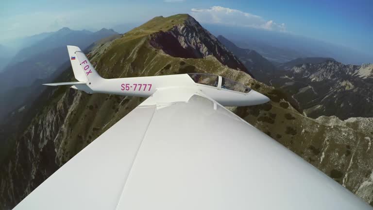 LD Glider flying above a green mountain ridge in sunshine