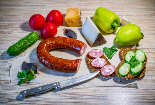 istock Products on the table – smoked sausage, brown bread, cheese and vegetables 1095394016