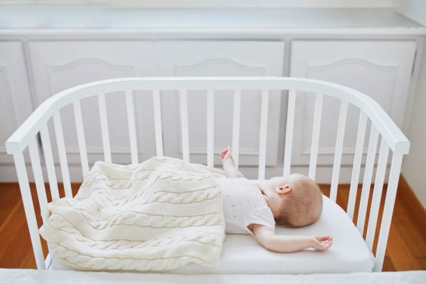 istock Baby sleeping in co-sleeper crib attached to parents' bed 1095402102