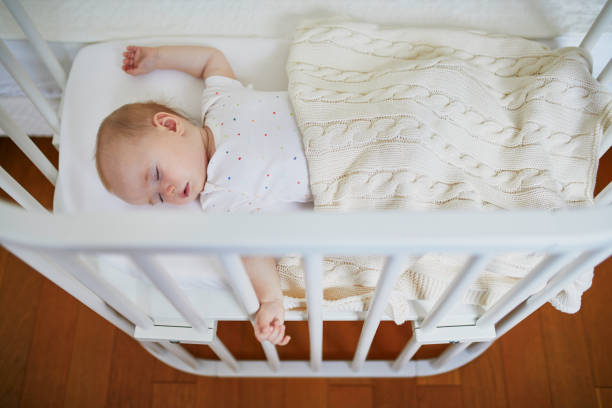istock Baby sleeping in co-sleeper crib attached to parents' bed 1095402286