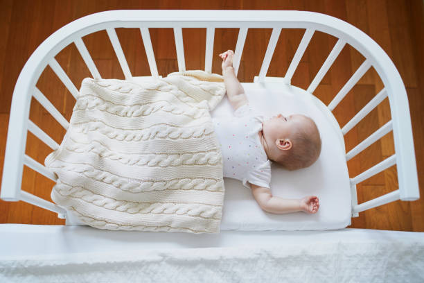 istock Baby sleeping in co-sleeper crib attached to parents' bed 1095402344