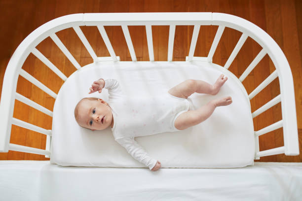 istock Baby girl in co-sleeper crib 1095402700