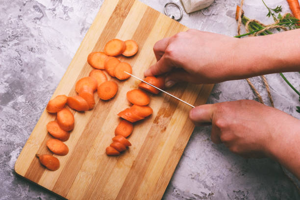 istock Women's hands cut carrots 1095412184