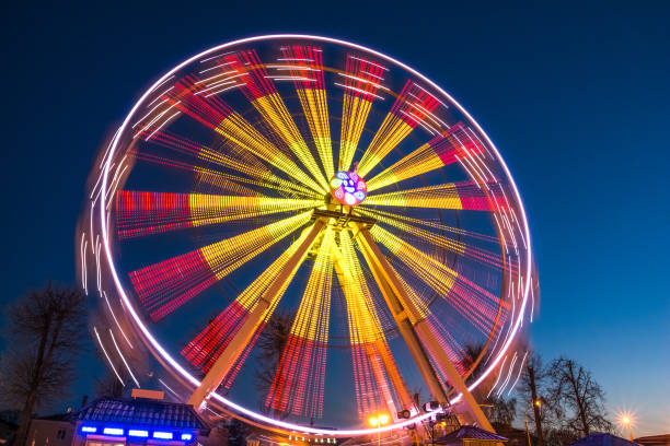 istock Ferris wheel at slow shutter speeds with a blue sky 1095412562