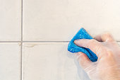 Tile joint is cleaned of dirt and mold with a sponge