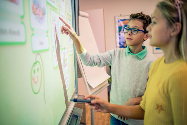 school friends working together on a project two school friends using the smart board for their project kids using smart board stock pictures, royalty-free photos & images