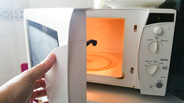 istock woman´s hand opening a white microwave 1095425086