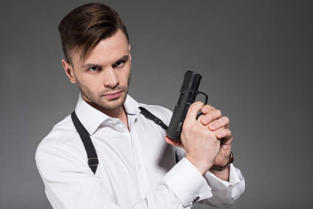 istock handsome secret agent with holster holding handgun, isolated on grey 1095431506