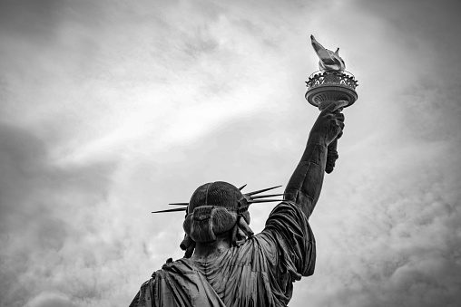 An unexpected view of the world famous Statue of Liberty in New York City. Captured in black & white against a dramatic sky.